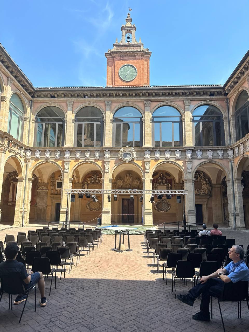 Дворец короля Энцо (Palazzo del Re Enzo). Внутренний двор дворца с портиками, часовой башней и подготовкой к мероприятию